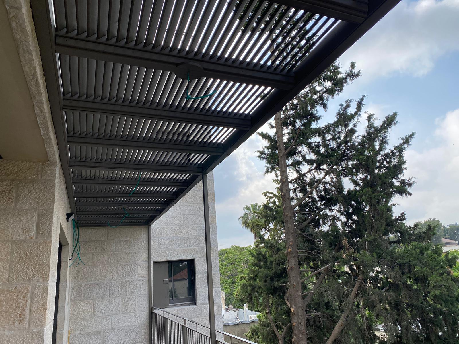 פרגולת רפפה מאלומיניום בגוון אנתרציט מעל מרפסת